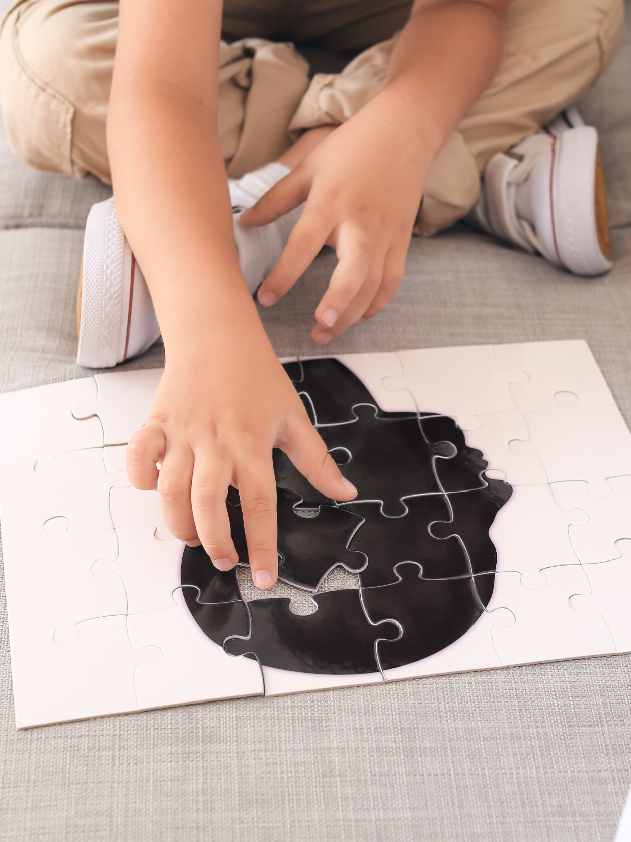 A child solving a puzzle shaped like a brain